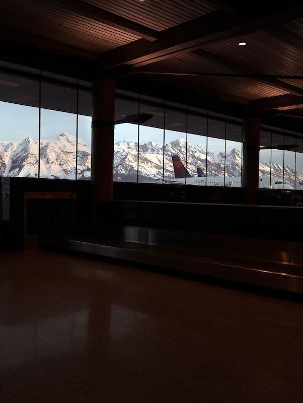Airport Terminal from Inside with Mountains and Plane